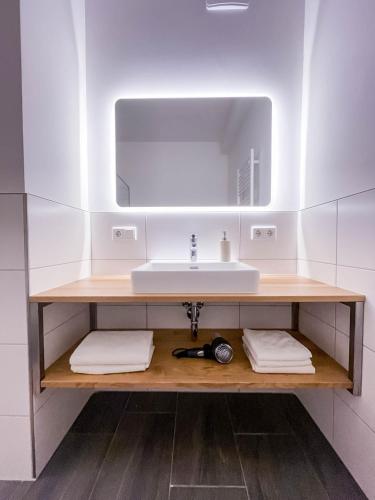 a bathroom with a sink and a mirror at Glüxplatzl GmbH Appartements am Wald in Sankt Martin am Tennengebirge