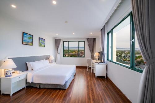 a hotel room with a bed and a large window at Ha Long Dream Hotel in Ha Long