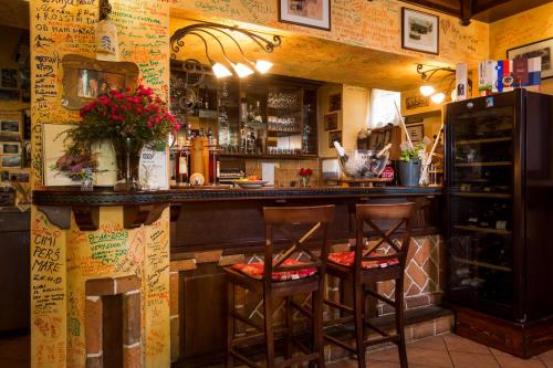 a bar with two stools sitting at a counter at Rooms & Restaurant Ostarija in Dolenjske Toplice