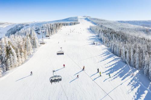 a group of people skiing down a ski slope at Magnus Resort in Szczyrk