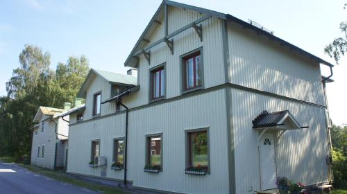 un bâtiment blanc avec des fenêtres sur le côté d'une rue dans l'établissement Sweden Slow Living, à Gösunda