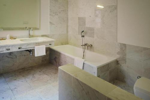 Baño blanco con bañera y lavamanos en Residence Villa Il Palagio, Rignano sull" Arno, en Rignano sullʼArno
