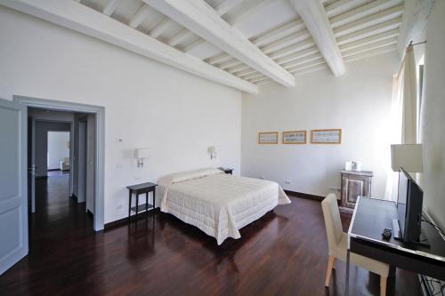 Schlafzimmer mit einem Bett, einem Schreibtisch und einem TV in der Unterkunft Residence Villa Il Palagio, Rignano sull" Arno in Rignano sullʼArno