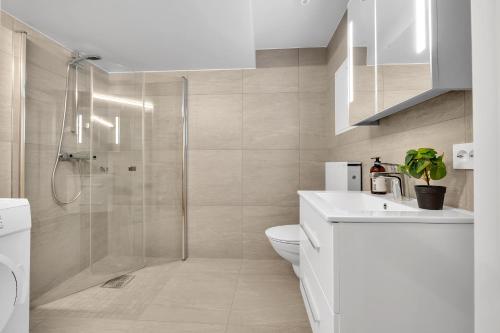 TA Storgata City Apartments في ترومسو: حمام مع دش ومرحاض ومغسلة