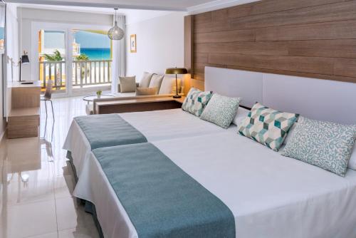 a bedroom with a large bed and a living room at Mediterraneo Bay Hotel & Resort in Roquetas de Mar
