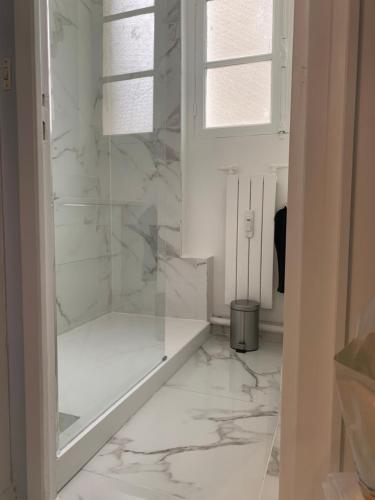 a bathroom with white marble floors and a window at Charming Eiffel Tower Appartement in Paris