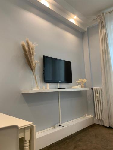 TV de pantalla plana en un estante de la pared en Charming Eiffel Tower Appartement, en París