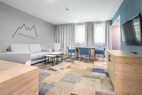 a living room with a couch and a table at Magnus Resort in Szczyrk