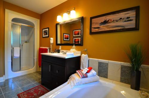 a bathroom with a tub and a sink and a mirror at Explorer House Bed & Breakfast in Niagara on the Lake