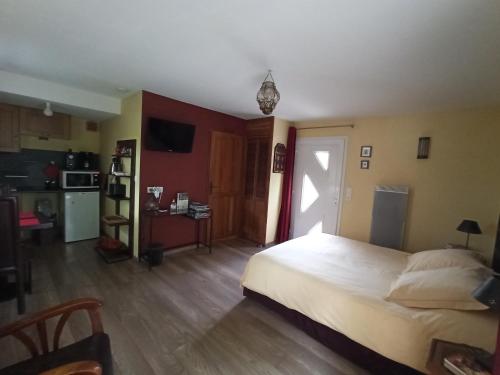 une chambre avec un grand lit et une cuisine dans l'établissement Au Cadran Solaire, à Nantes