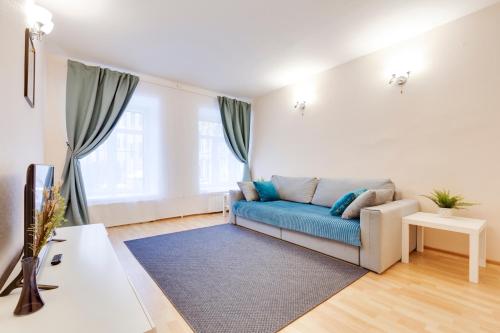 uma sala de estar com um sofá azul e uma mesa em Квартира у Эрмитажа на Наб. Мойки 16 em São Petersburgo