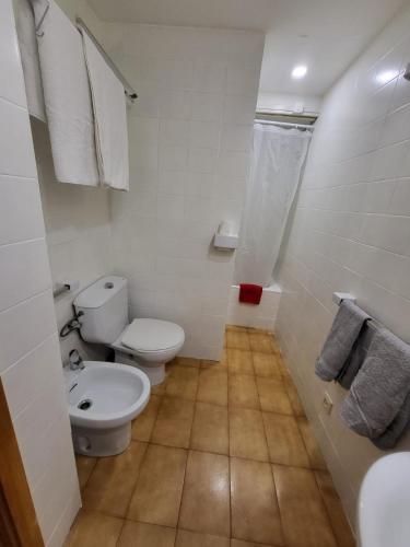 a white bathroom with a toilet and a sink at Apto VIELHA CENTRO Internet fibra in Vielha