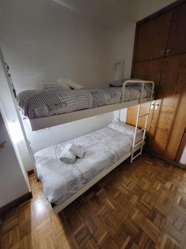 two bunk beds in a room with a wooden floor at Apto VIELHA CENTRO Internet fibra in Vielha