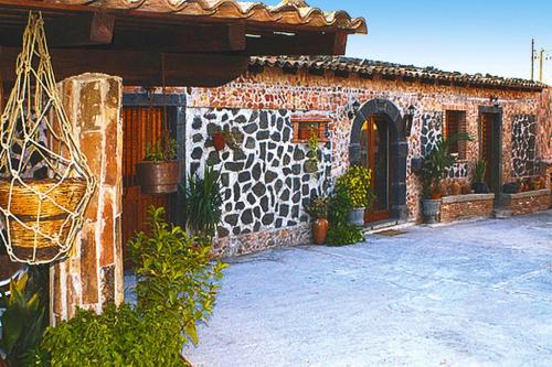 una casa con una pared de piedra con plantas. en Holiday home Castiglione di Sicilia, en Castiglione di Sicilia
