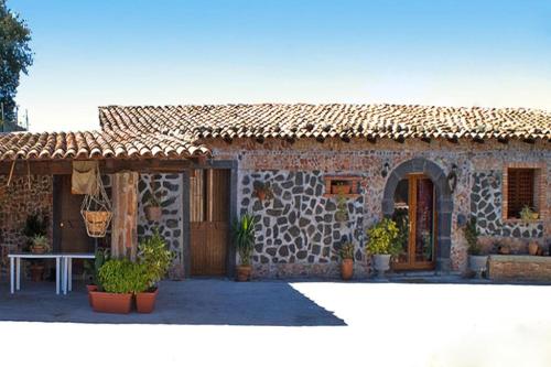 een stenen huis met een tafel ervoor bij Holiday home Castiglione di Sicilia in Castiglione di Sicilia
