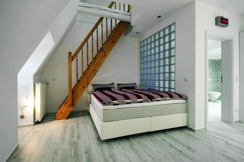 1 dormitorio con 1 cama y escalera en Apartment SL Lounge, Luebben, en Lübben