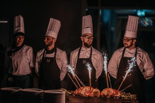 a group of chefs standing in front of a table with meat at Magnus Resort in Szczyrk