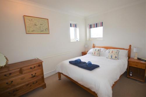 a bedroom with a white bed with blue towels on it at Anchor Cottage in East Cowes