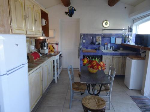 une cuisine avec une table avec un vase de fleurs dessus dans l'établissement un lit en provence, à Éguilles