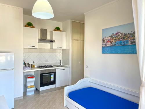 una cucina bianca con panca blu in una stanza di Appartamento Indipendente al Mare Sweet Apartments a Santa Marinella