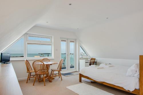 a bedroom with a bed and a table and chairs at A Spacious Seaside house in Hampton, Herne Bay in Herne Bay