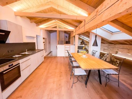 a kitchen and dining room with a wooden table at Glüxplatzl Appartements am Wald in Sankt Martin am Tennengebirge