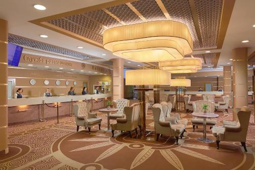 a hotel lobby with tables and chairs and a salon at Izmailovo Gamma Hotel in Moscow
