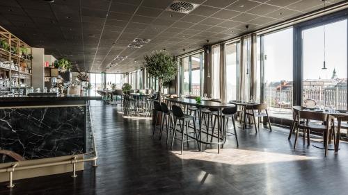 a bar with chairs and tables in a room with windows at Clarion Hotel Sundsvall in Sundsvall