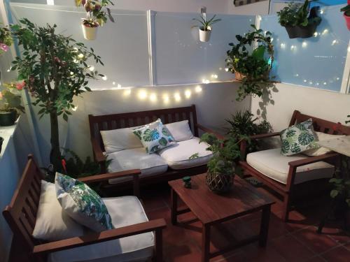 フエンヒロラにあるFenix con piscina y terrrazaのソファ2台とテーブル、植物が備わる部屋