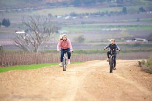 two women riding bikes on a dirt road at Rooikraal Farm Rondawel in Prince Alfreds Hamlet