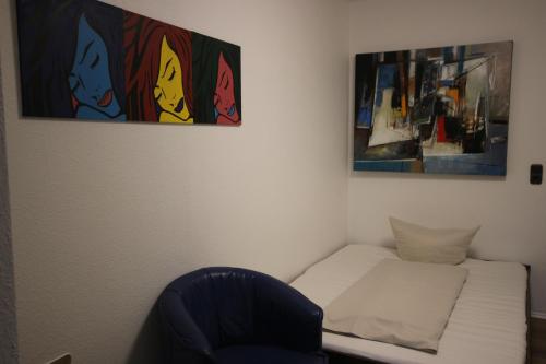 a small room with a bed and a chair at Hotel Nüller Hof in Wuppertal