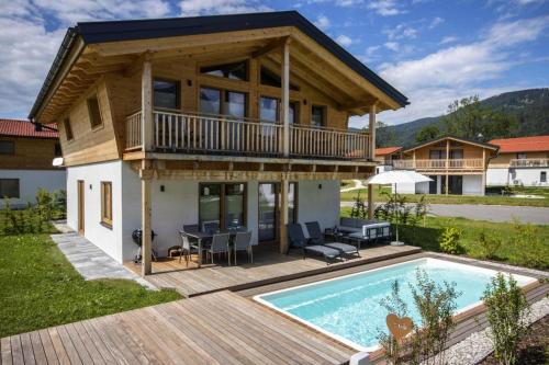 a house with a deck and a swimming pool at Bergchalet Falkenstein, Inzell in Inzell