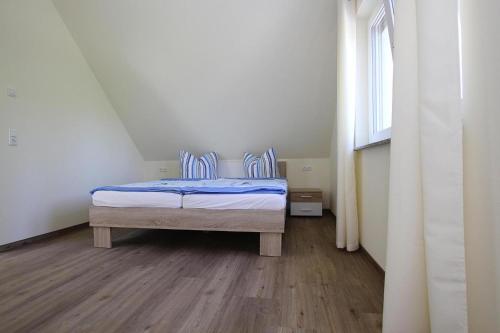 a bedroom with a bed with blue sheets and a window at Apartment Hafenflair am Plauer See, Plau am See in Plau am See