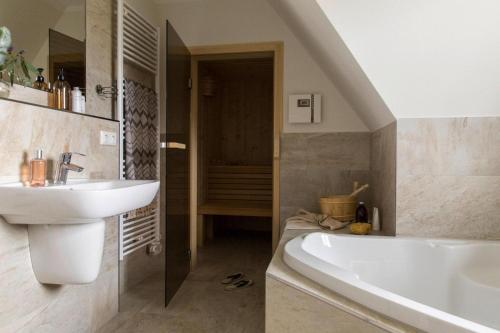 a bathroom with a sink and a bath tub at Holiday house, Fuhlendorf in Fuhlendorf