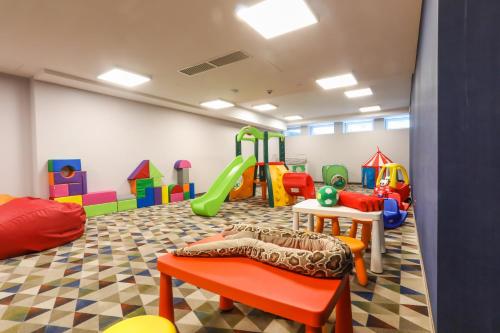 a childrens play room with a slide and a playground at Magnus Resort in Szczyrk