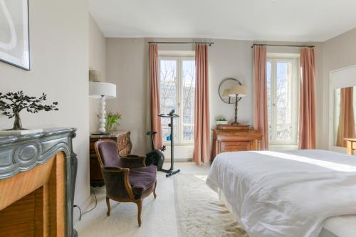 une chambre avec un lit, un bureau et des chaises dans l'établissement Superbe appart de 129m2, 3 ch-Neuilly 2 min Paris, à Neuilly-sur-Seine