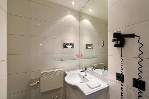 a bathroom with a sink and a mirror at Apart Hotel Amadeo in Zofingen
