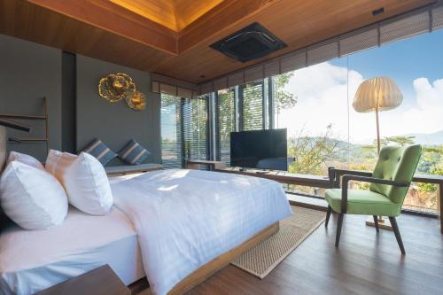 a bedroom with a large white bed and a television at AKRA Collection Layan in Layan Beach