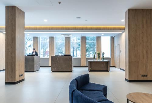 an office lobby with wood dividers and a blue couch at Magnus Resort in Szczyrk