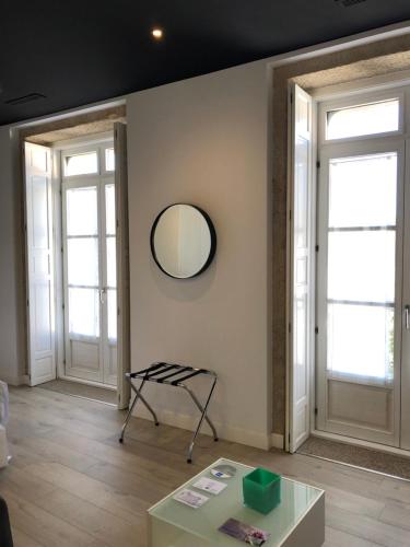 a room with two windows and a table and a mirror at Hotel Montes in Santiago de Compostela