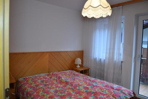a bedroom with a bed with a colorful blanket at Casa Maddalena in Canazei