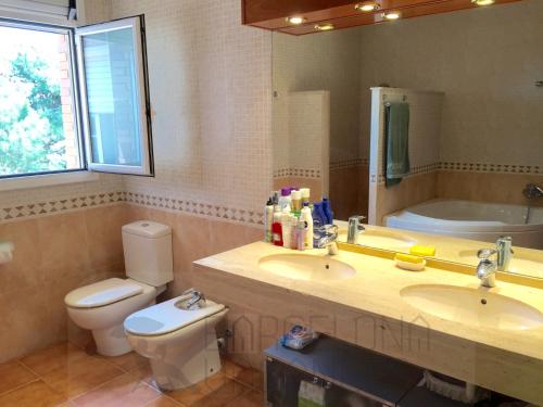 a bathroom with a sink and a toilet and a mirror at BarcelonaVacances-Villa Lucia in San Pol de Mar