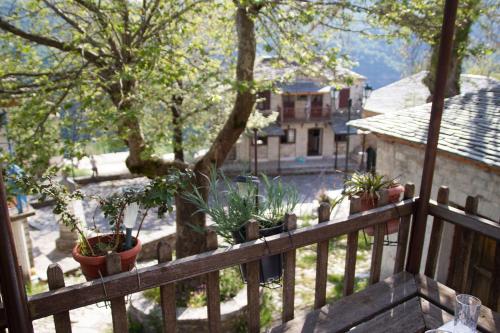 a wooden fence with potted plants on a balcony at Napoleon Zaglis Guesthouse in Kalarrites