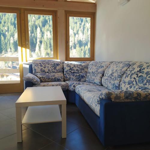 a blue couch in a living room with a table at Appartamento Mary - Casa Green - Dog friendly, box auto in Cogolo