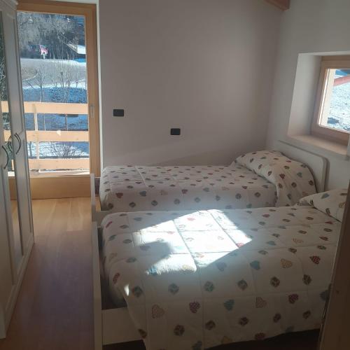 a bedroom with a bed and a window and a door at Appartamento Mary - Casa Green - Dog friendly, box auto in Cogolo