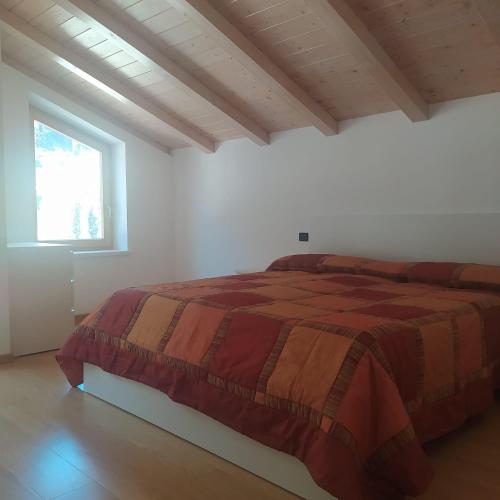 a bedroom with a bed in a white room at Appartamento Mary - Casa Green - Dog friendly, box auto in Cogolo