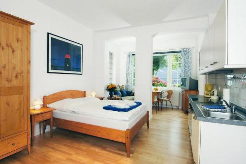 een kleine slaapkamer met een bed en een keuken bij Holiday flat Wyk auf Föhr - DNS10100i-P in Wyk auf Föhr