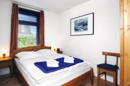 ein Schlafzimmer mit einem Bett und einem Fenster mit Handtüchern darauf in der Unterkunft Holiday flat Wyk auf Föhr - DNS10100i-P in Wyk auf Föhr