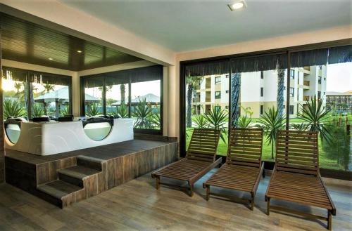 a bathroom with two chairs and a bath tub at VG SUN Apartamento com vista para o mar - High speed internet in Caucaia