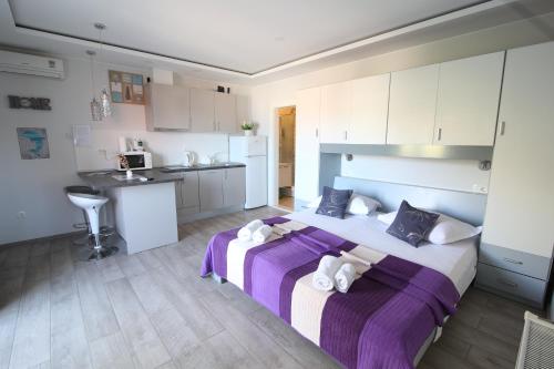 a bedroom with a large bed and a kitchen at Apartments Viola in Tučepi